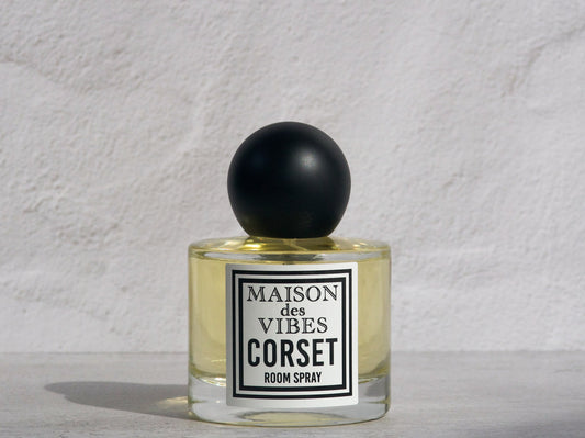 Room spray bottle labeled 'MAISON des VIBES CORSET' on a textured white background. CORSET is a non-toxic room spray.