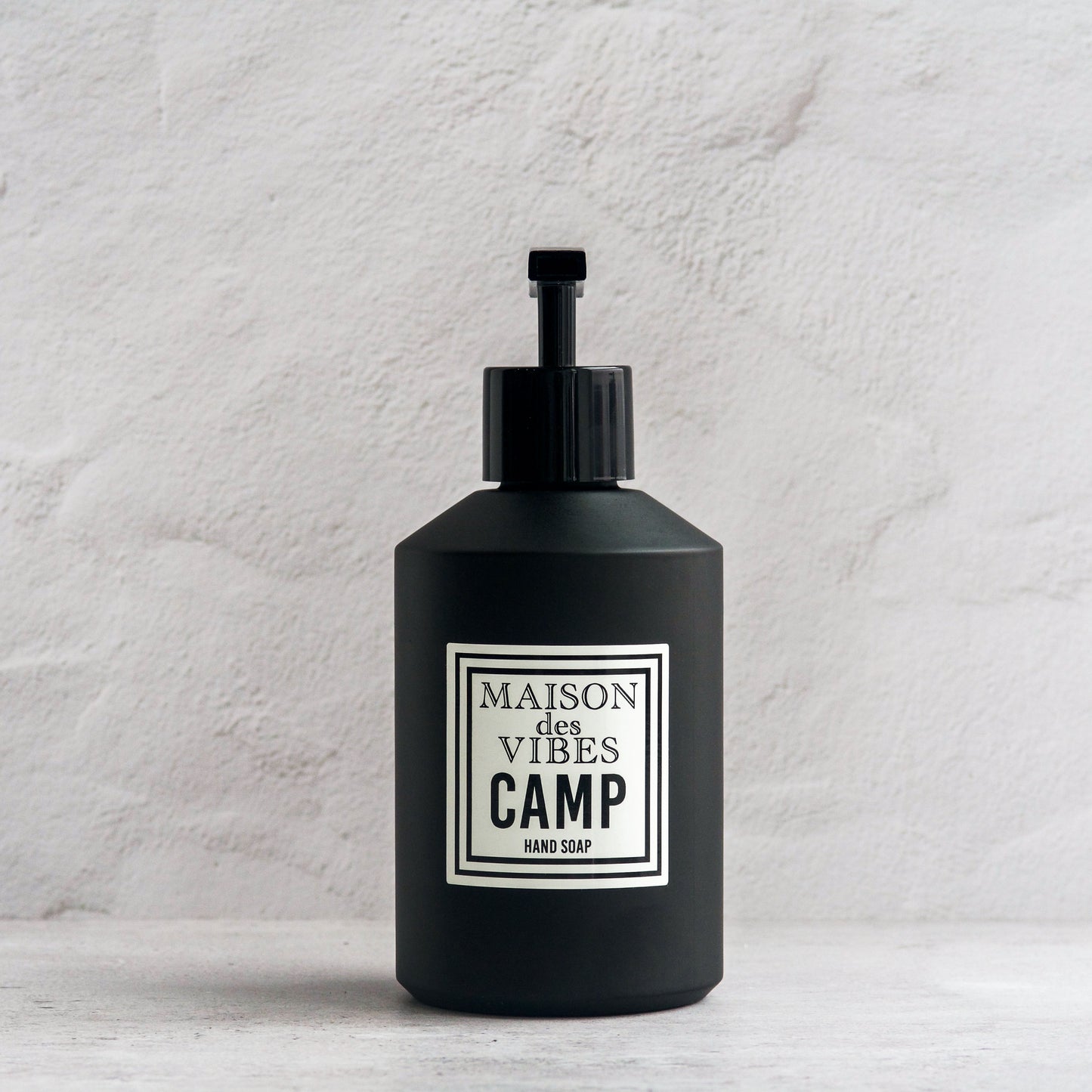Maison des Vibes' Camp liquid hand soap in the classic black bottle with a white and black square logo on a white background. 