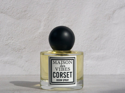 Room spray bottle labeled 'MAISON des VIBES CORSET' on a textured white background. CORSET is a non-toxic room spray.